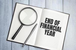 End of Financial Year word concept on notepad and magnifier photo