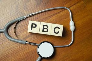 PBC Primary biliary cholangitis - word from wooden blocks with letters on wooden background photo