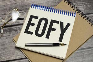 notebook with the word End of Financial Year on wooden background photo