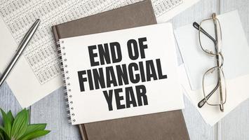 Text End of Financial Year on a notebook on the diagram and charts with calculator and pen photo