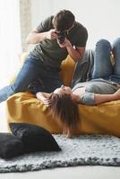 On the work. Photographer taking a shot of young girl that lying on the white sofa photo