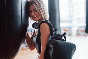 Just having fun. Adult female with black bag and headphones in the training gym photo