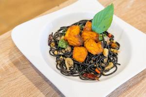 black spaghetti with salmon fried garlic chili pepper sauce photo