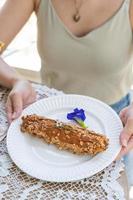 Homemade puff pastry deep fried Eclairs with vanilla cream topping with almonds nut on white plate over table top with lace tablecloth. traditional french dessert. selective focus photo