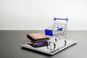 Tablet with shopping cart on wood , Means shopping online photo