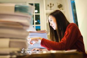 Asian woman freelancer worried about the deadline of her report. Workaholic people concept photo