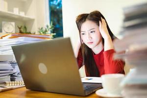 Stressed freelancer checking reports and accounting in computer, working overtime at home office photo