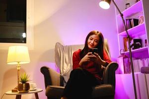 Young woman use smartphone at home in night time. technology, internet and people concept photo