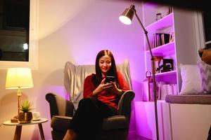 Technology, internet and people concept. Young woman use smartphone at home photo