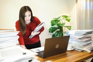 Woman doing overtime about urgent job and stand at desk at home at night. Workaholic people concept photo