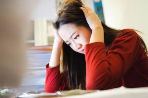 A Stress Student has a headache during doing homework on a desk at home at night time. photo