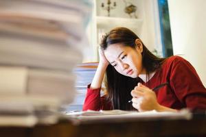 A Headache Woman during doing overtime to keep the deadline of her report. Workaholic people concept photo