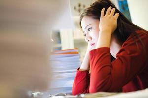 A Stress Student makes reports by computer at home at night time. photo