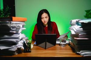 Asian woman freelancer worried about the deadline of the report during using digital tablet photo