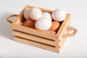 los huevos de pato y los huevos de gallina se ponen en una cesta de madera foto