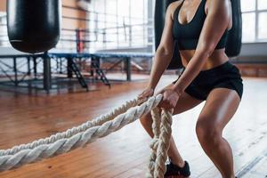 Productive exercise. Blonde sport woman with ropes in the gym. Strong female photo