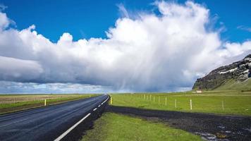 bela natureza da Islândia. estrada vazia pela islândia com tempo ensolarado e nuvens chuvosas ao fundo. a estrada número 1 é a estrada principal da Islândia. 4k