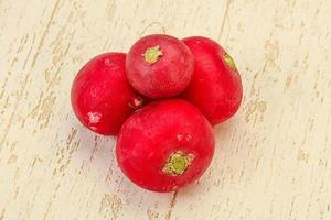 Ripe fresh radish heap over wooden photo