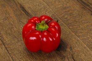 Ripe Red bell pepper over wooden photo