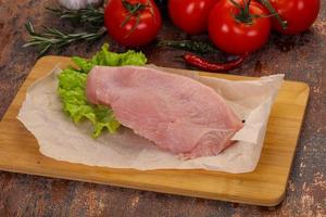 Raw Turkey steak served rosemary photo