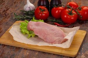 Raw Turkey steak served rosemary photo