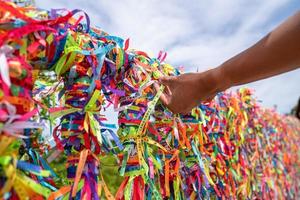 Closeup of colorful ribbons in Arraial D'Ajuda, Bahia, Brazil. Man hand making an order with Brazilian ribbons photo