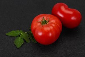 Ripe tomato over wooden background photo