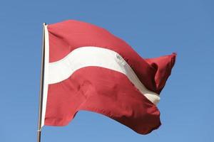 Latvian flag flying on flagpole photo