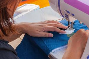 Woman's hands, doing her patchwork using sewing machine photo