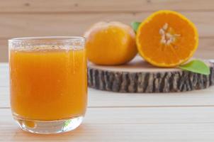 Cold orange juice on wooden table photo
