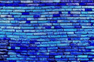 Old brick wall texture background in blue color tone photo