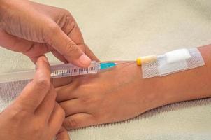 Doctor holding syringe in hand injects to a patient arm photo