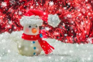 hombre de nieve sobre fondo rojo y blanco borroso para la decoración de navidad año nuevo foto