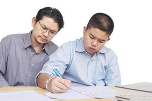 padre enseñando seriamente la tarea del hijo foto