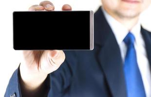 Soft focused of blank mobile phone in the right hand of blurred young businessman background photo