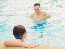 Father teaching his son in a swimming pool photo