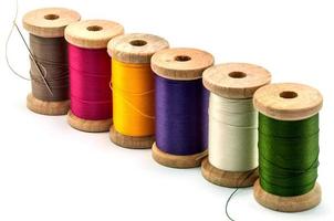 Isolated wooden spools of thread with a needle photo