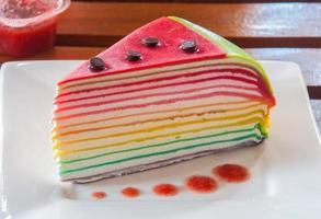 Rainbow crepe cake on a wooden table photo