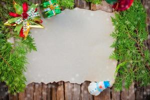 tarjeta de navidad en blanco sobre fondo de textura de madera con otros artículos de decoración foto
