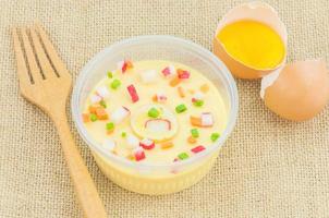 Thai steamed egg with fresh beaten egg and fork decoration on sack background photo