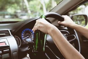 Woman drinking beer while driving a car photo