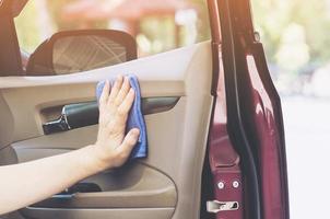 la mano del hombre está limpiando y encerando el auto foto