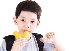 Boy eating ice cream isolated over white background photo