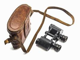 Old antique binoculars and its brown leather bag cover isolated over white background photo
