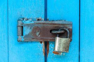 Old blue wooden door with rusty padlock and lock for background use photo