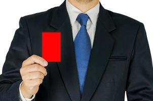 el hombre de negocios está mostrando una tarjeta roja aislada en blanco. la foto incluye dos trayectorias de recorte, fondo blanco y tarjeta.