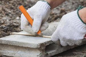 Construction worker is working with cement block measurement prepare for cutting. photo