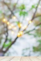 Blur abstract of light bokeh with tree branch background with white wooden terrace photo