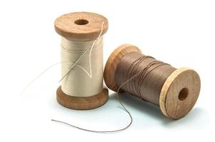 Isolated wooden spool of thread and needle photo