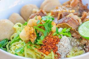 Thai - Chinese style spicy noodle with steamed pork and pork ball served with fresh vegetable and soup photo